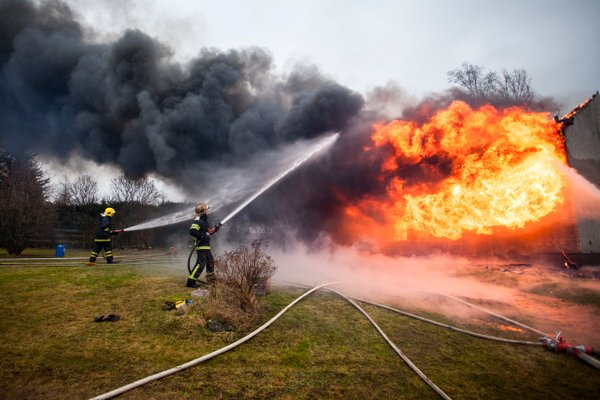 Kuvassa tulipalo ja palokuntalaisia sammuttamassa tulta vesiletkuilla